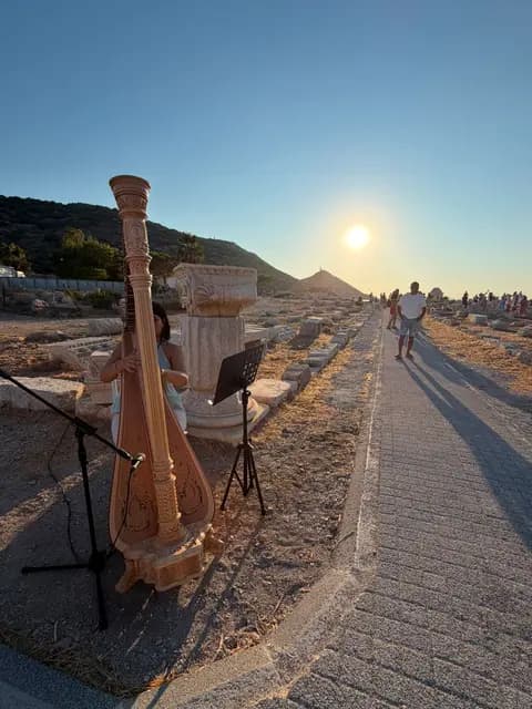 A harpist plays among the ancient columns of Knidos as the sun sets at the end of the sacred way.