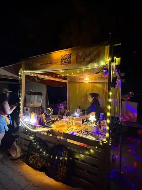 At night the MMM-branded wooden kiosk glows with fairy lights as an attendant prepares an order.