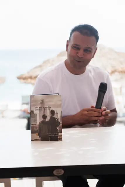 At the seaside talk table a guest takes the microphone and begins to speak.