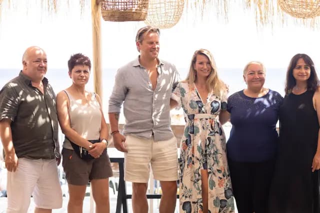 Festival guests line up under the reed canopy for a group photograph.