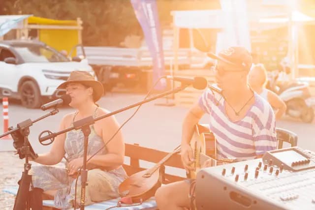 The evening sun leaks in behind the microphones as the duo plays on.