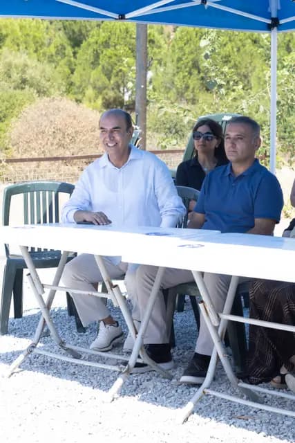 Panel speakers smile at the table as they wait their turn.