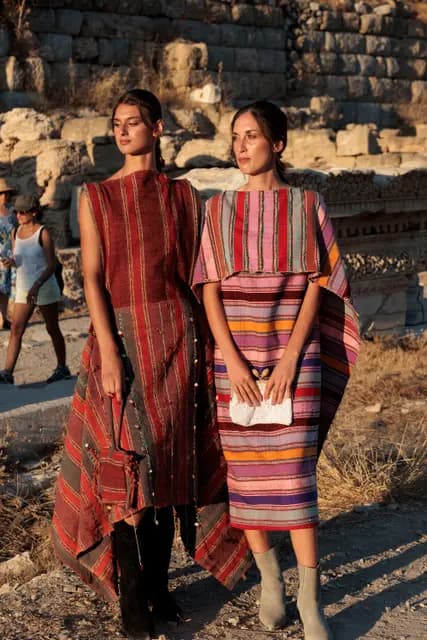 Two handwoven looks side by side against the stone walls of Knidos.