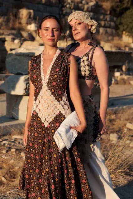 Two models look into the camera shoulder to shoulder, the collection's range of patterns in one frame.